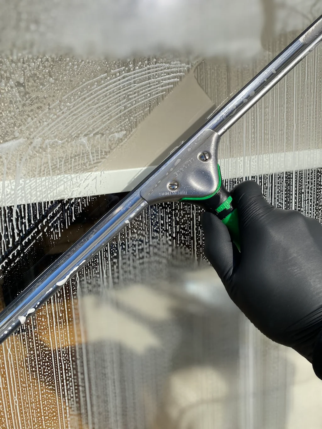 Hands with squeegee on sash window